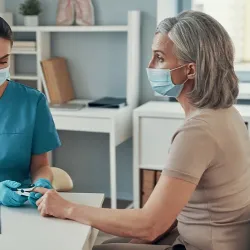 An older woman being examined by a nurse